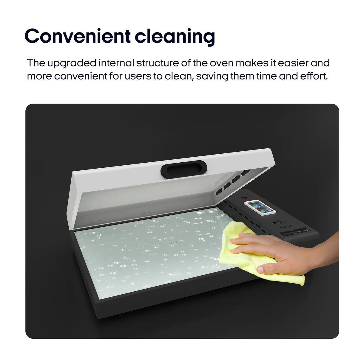 Hand cleaning an open DTF oven with a yellow cloth on a black background