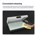 Hand cleaning an open DTF oven with a yellow cloth on a black background